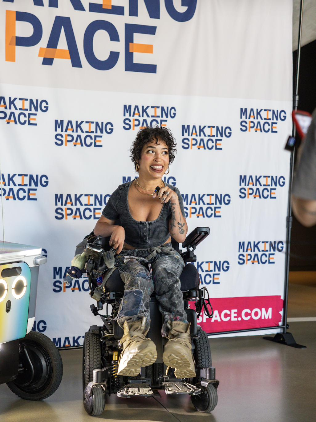 A disabled women in front of a making space step and repeat