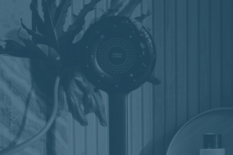 Contemporary black showerhead against wooden panels and patterned wallpaper with green plant and bathroom accessories.