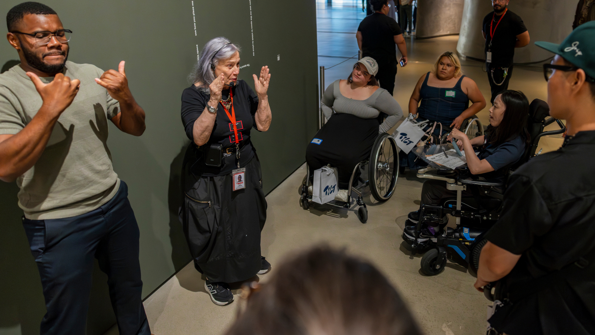 Picture of Making Space community members watching a presenter and ASL interpreter explain an art exhibition at The Broad.