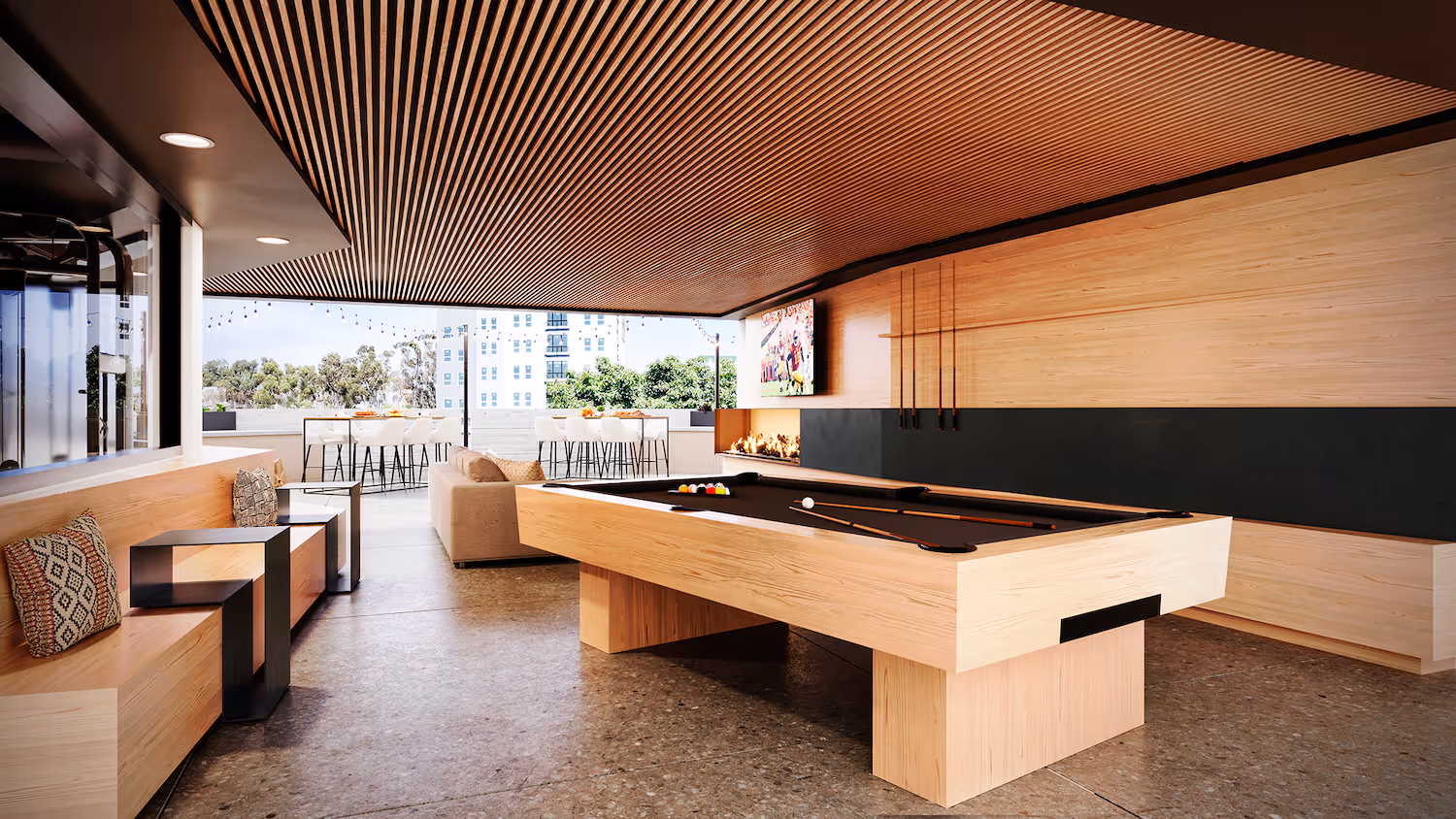 Outdoor gaming deck with a pool table, lounge seating, and a TV, providing a unique amenity at Tessera in Los Angeles, CA.