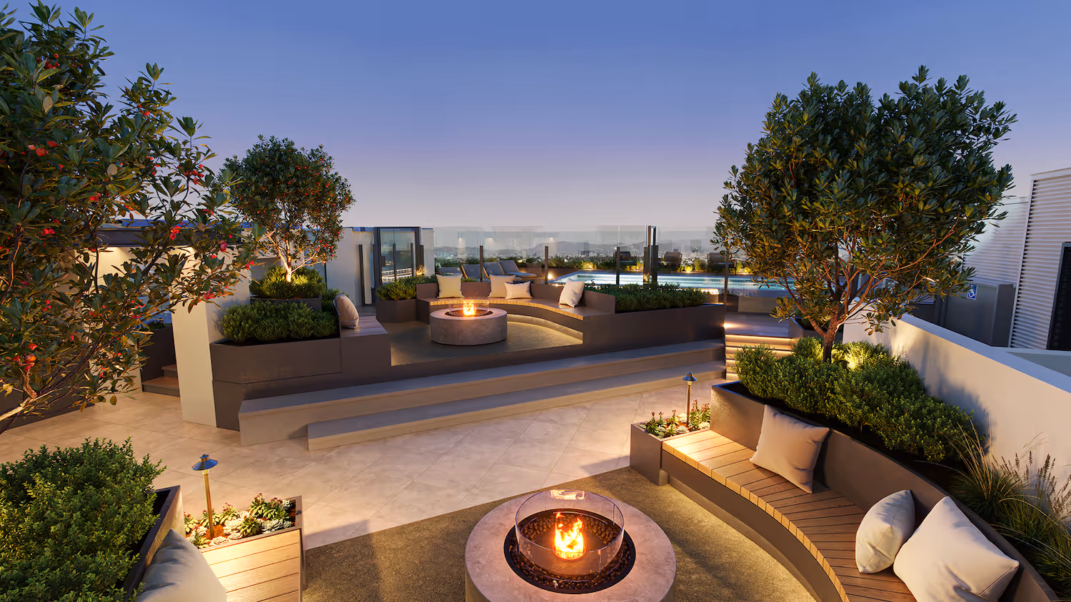 Rooftop amenity deck with a cozy fire pit and built-in benches under the evening sky, offering a social space at Tessera in Los Angeles, CA.