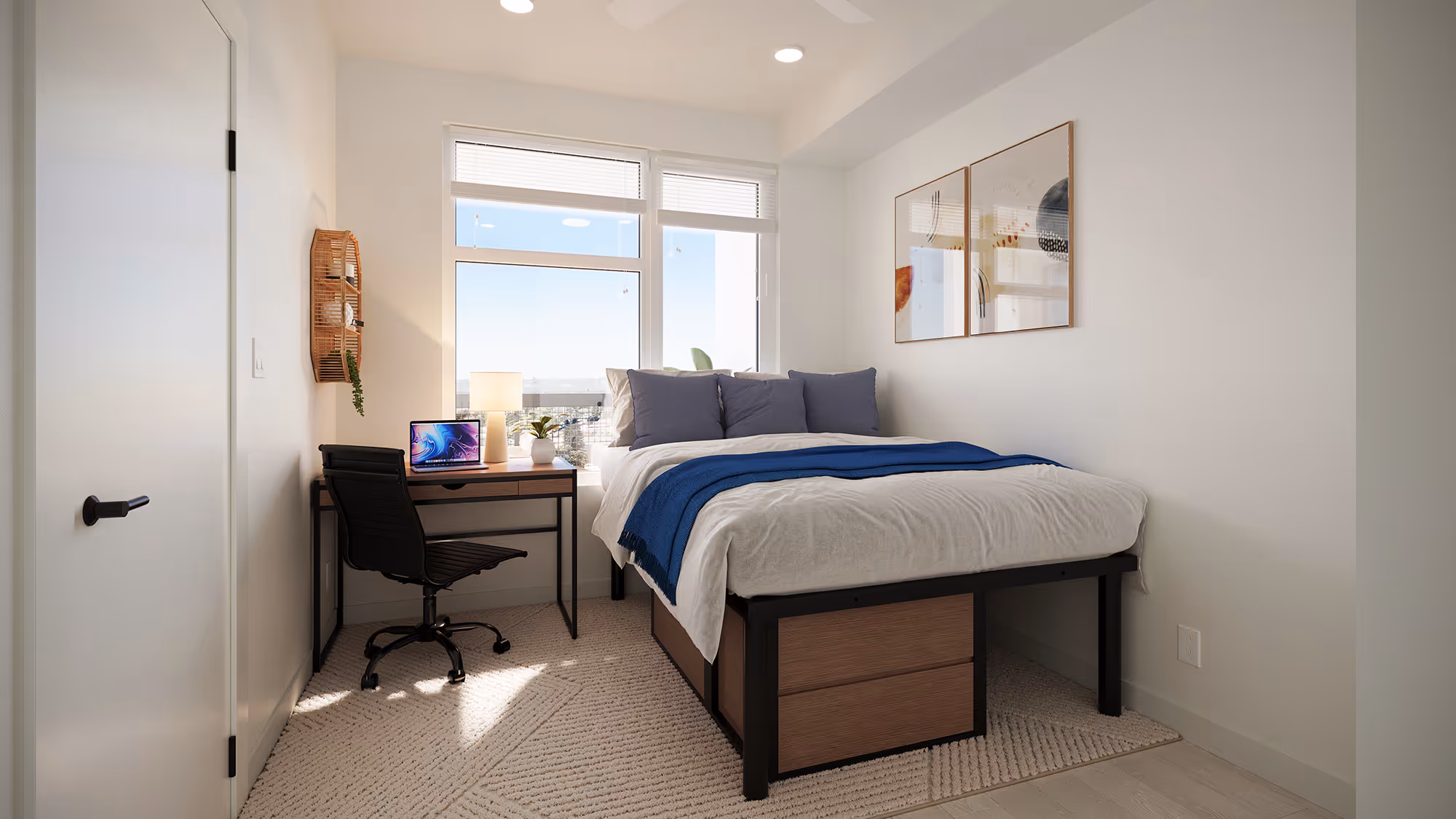 Functional bedroom featuring a bed, a desk with a laptop, and a large window, ideal for student living at Tessera in Los Angeles, CA.