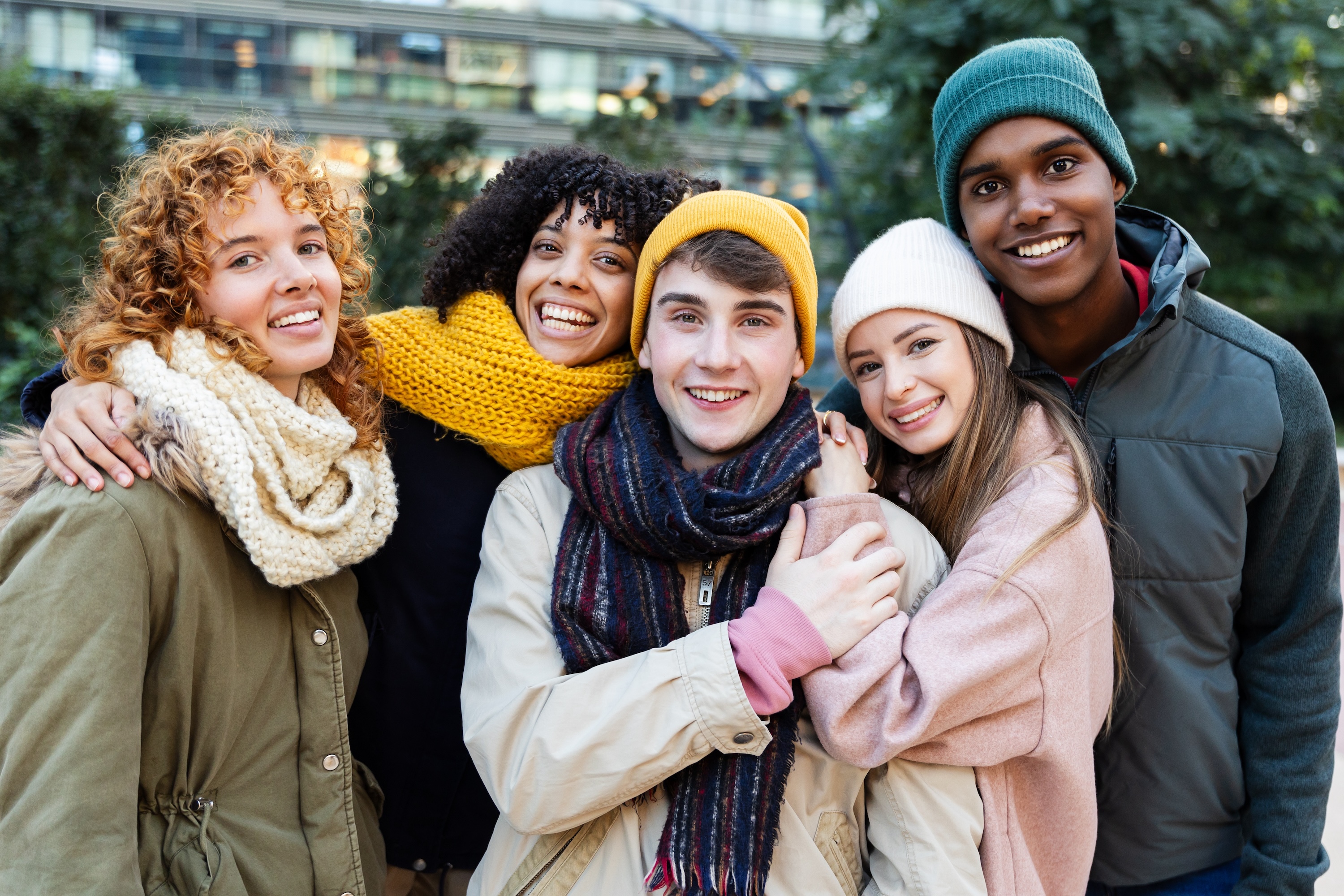 Group of residents in seasonal attire smiling together outside near Tessera, a modern community in Los Angeles, CA.