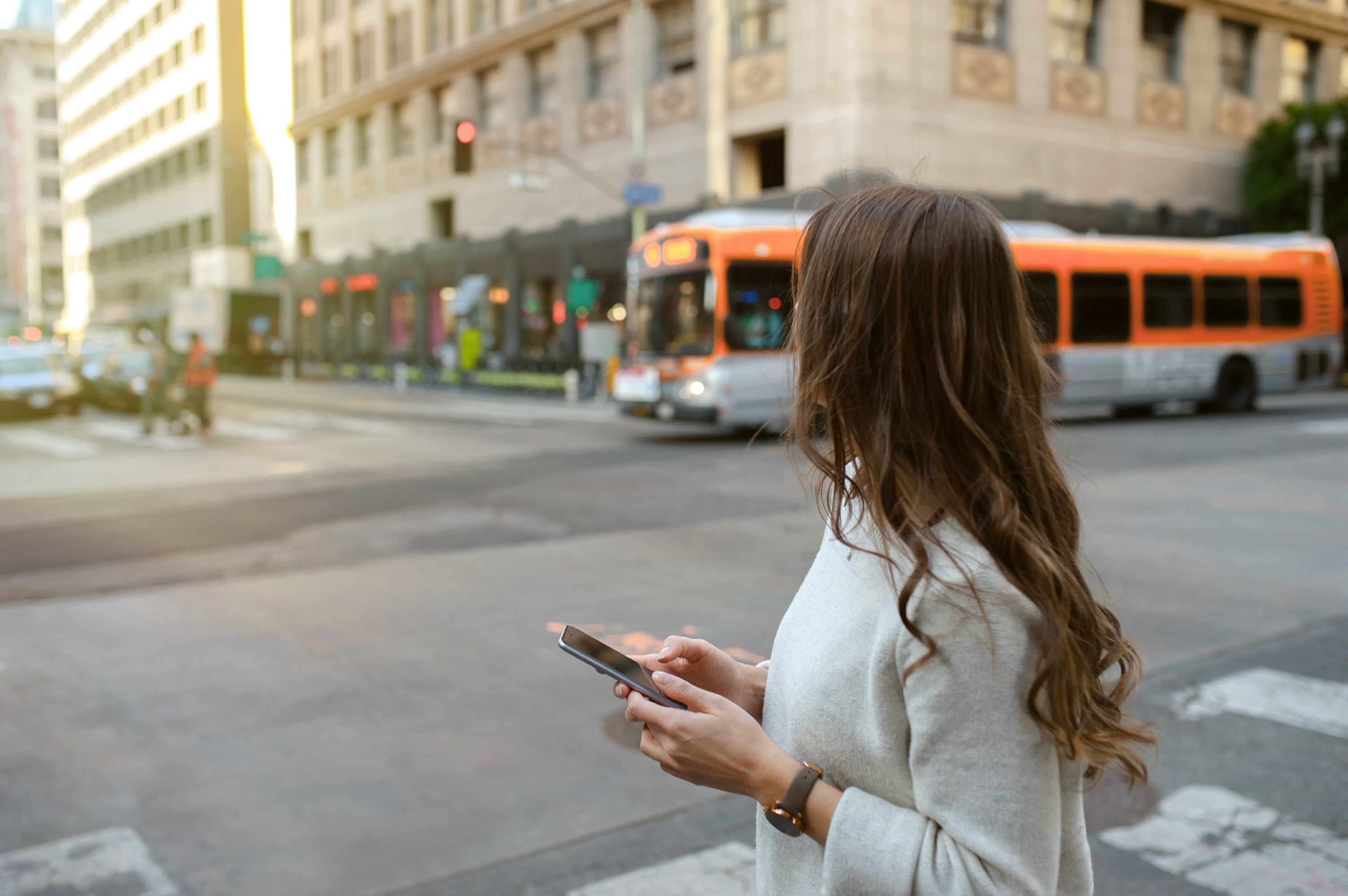 A person navigating the vibrant city streets near Tessera luxury apartments, located steps away from major bus lines.