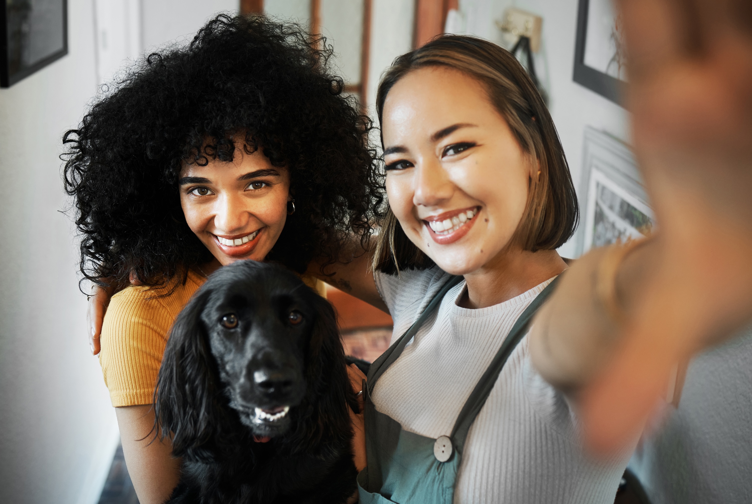 Neighbors taking a selfie with their dog in a modern living space at Tessera pet-friendly apartments.