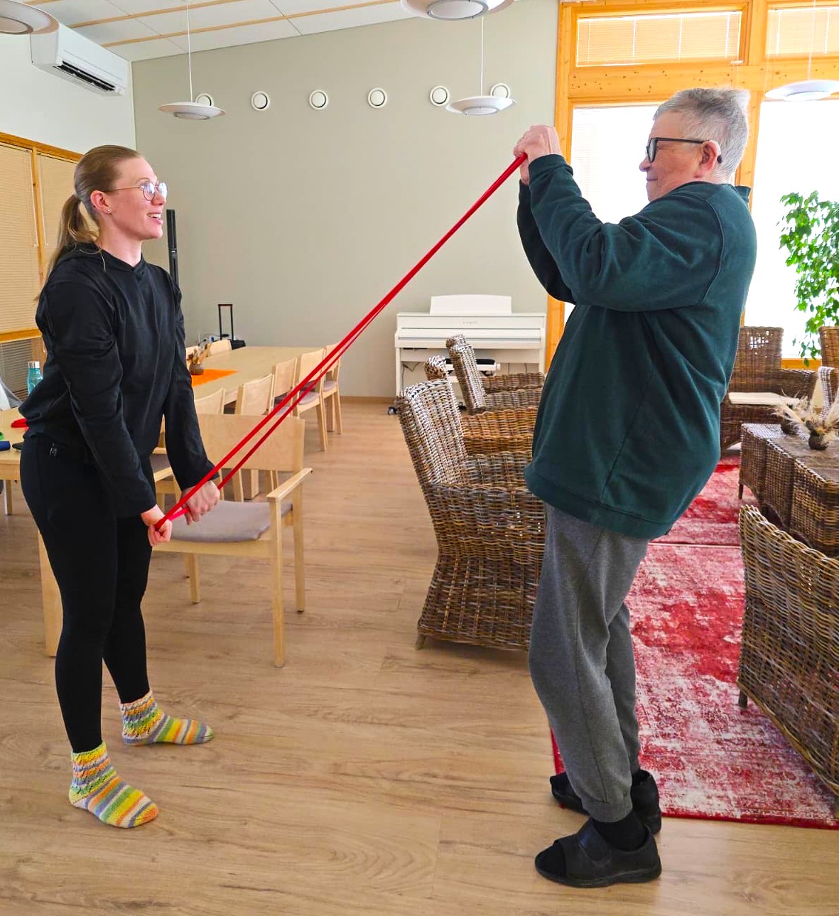 Ohjaaja ja osallistuja kuminauhan kanssa.