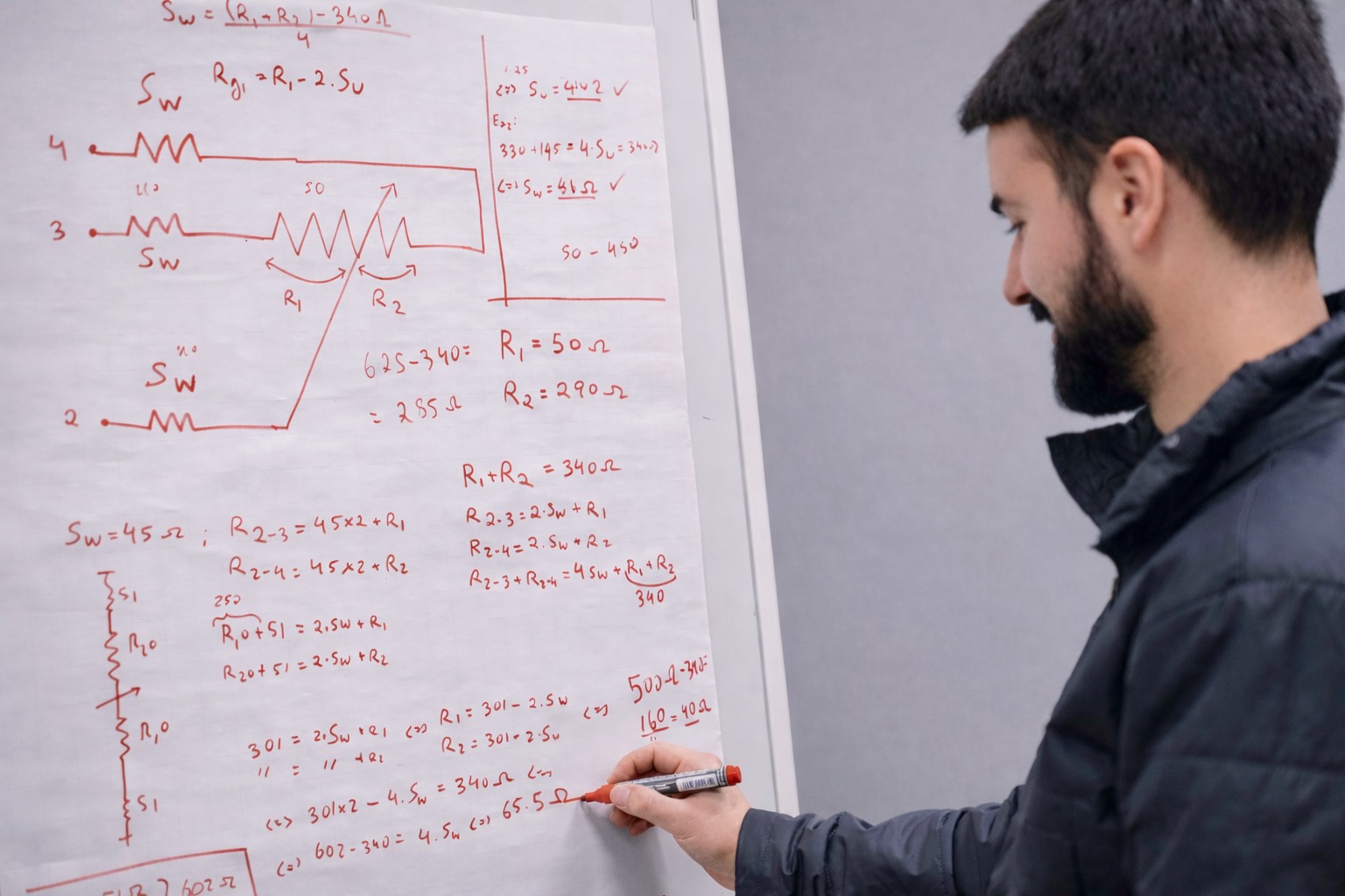 Mann schreibt eine Berechnung auf eine Flipchart