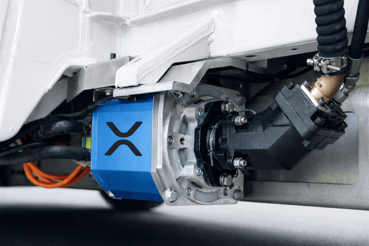 Elektronik von dem ePTO Stromabgang. Ein elektrischen Nebenantrieb als blauer Kasten mit Verkabelungen. Die Mechanik ist unterhalb eines Fahrzeuges befestigt.