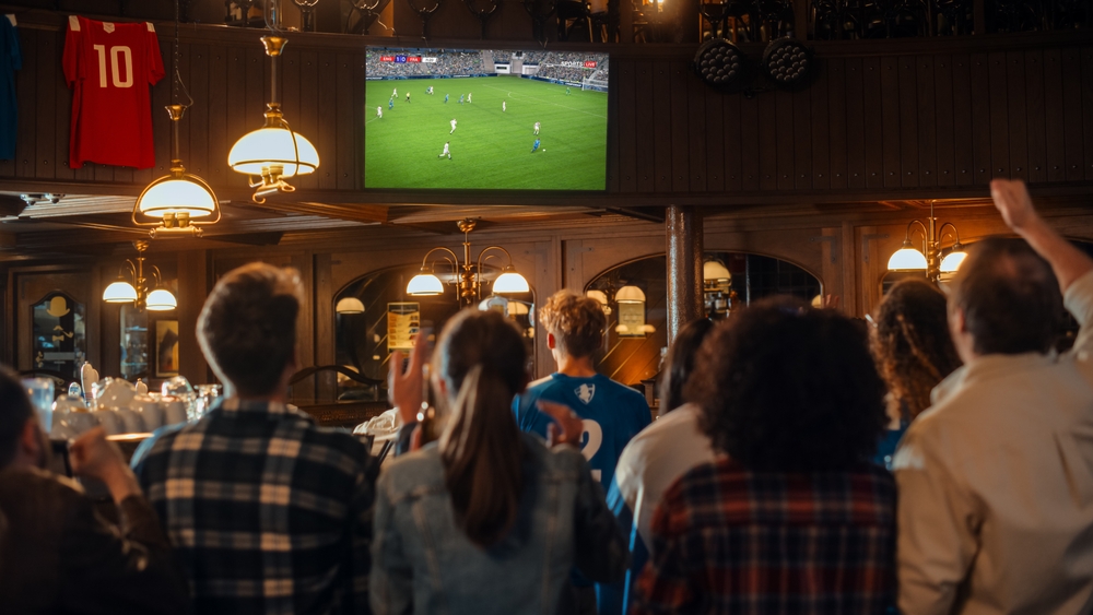 lots of people watching sport in a pub
