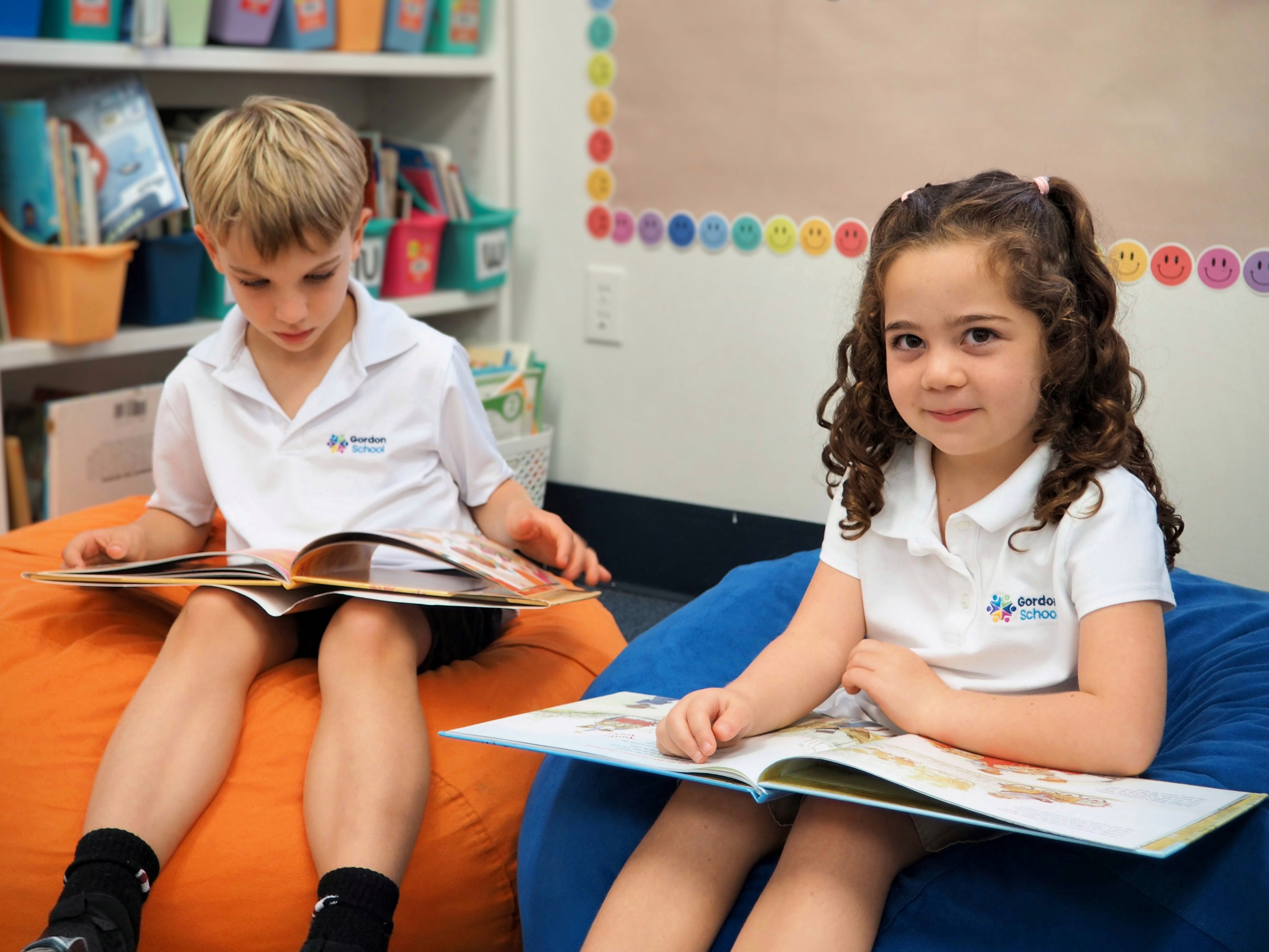 Two Gordon School students reading books in a classroom