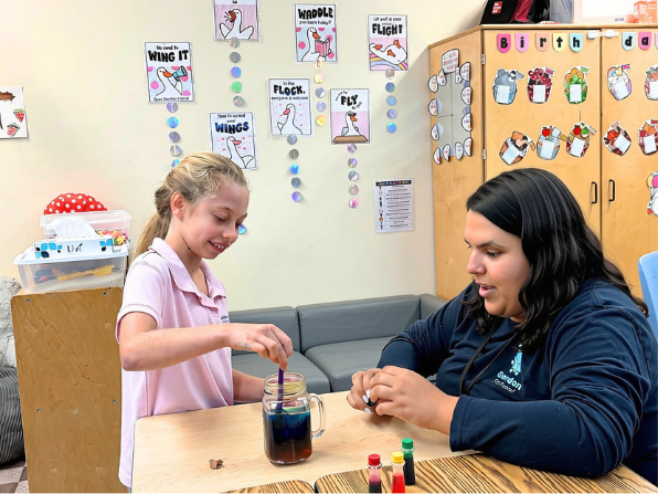 A Tikvah Center student doing a color-mixing science experiment with her teacher