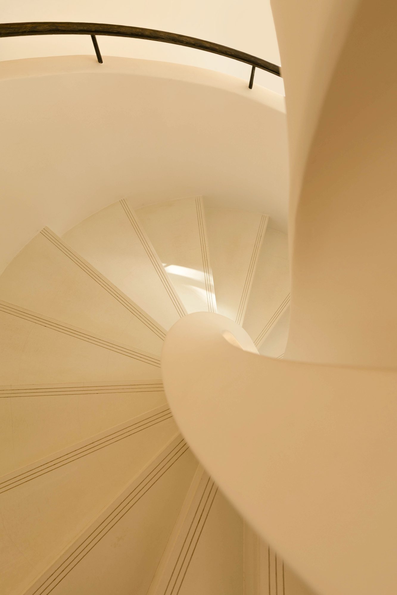 Vue plongeante dans l'escalier hélicoïdal en micro-béton blanc, Maison Espaces