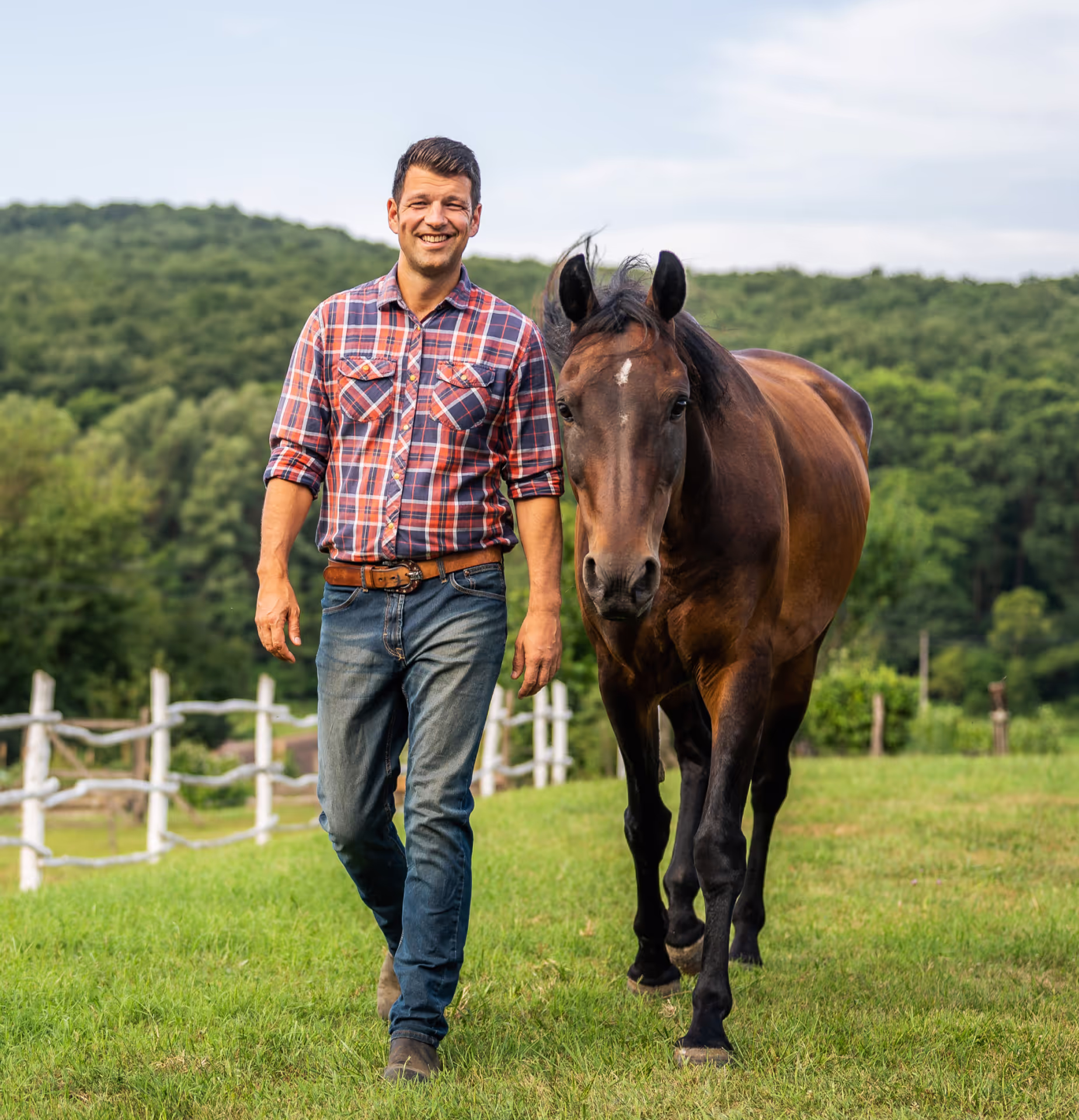 Vezetői képzés a gyakorlatban: egy férfi a földről irányít egy lovat, fejlesztve a non-verbális kommunikációt.
