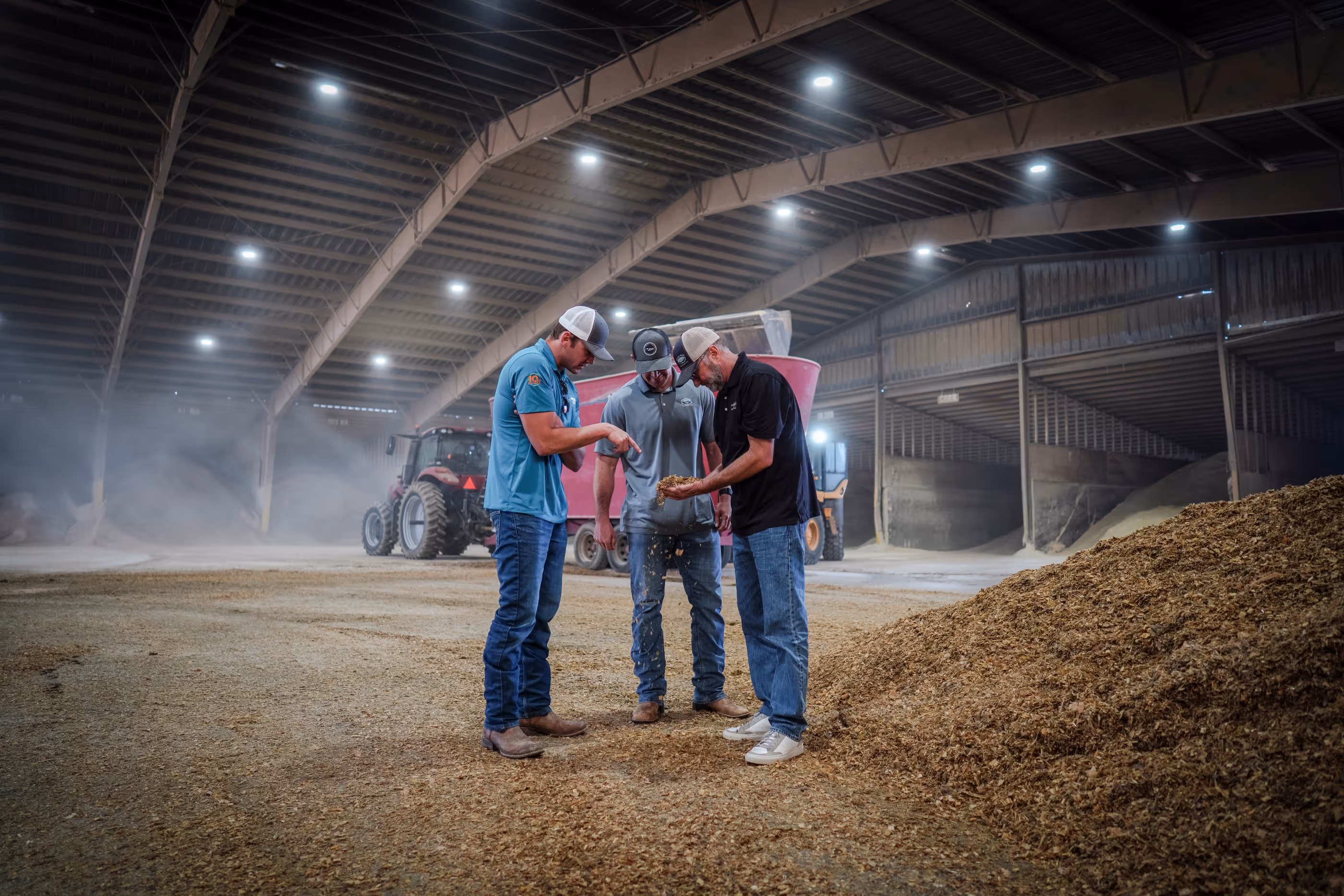 Dairy farmers pointing and looking at at silage.