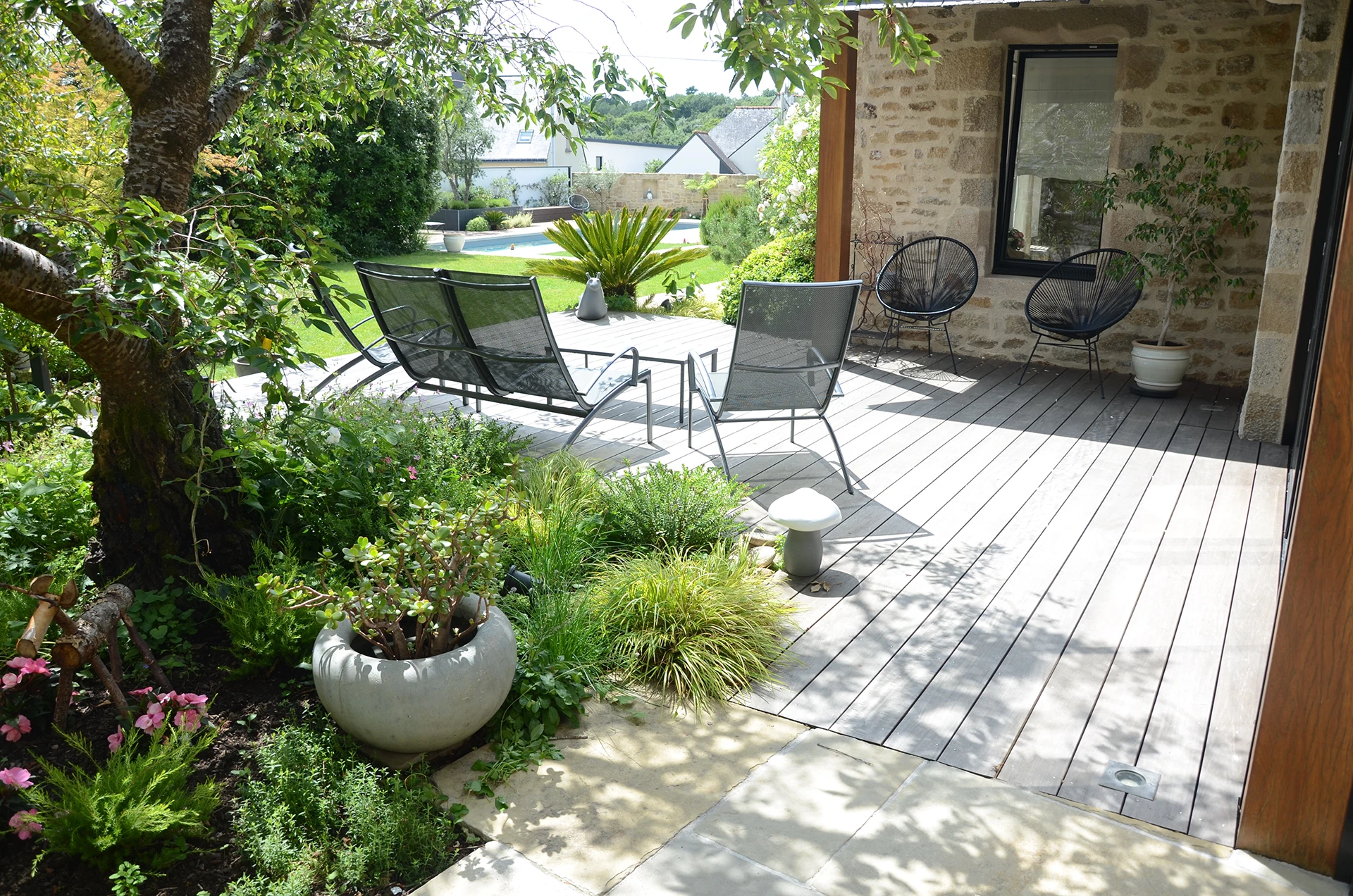 Mélange de matériaux pour cette terarsse bois et pierres dans la région d'Auray, réalisée par Henri Mignon paysagiste