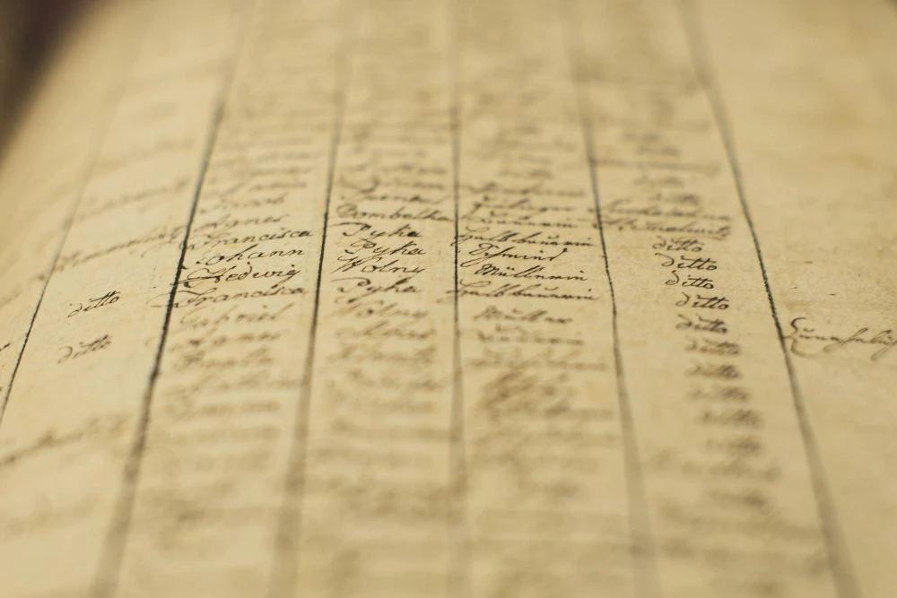 Close-up of an aged handwritten record book page with column lines and cursive entries.