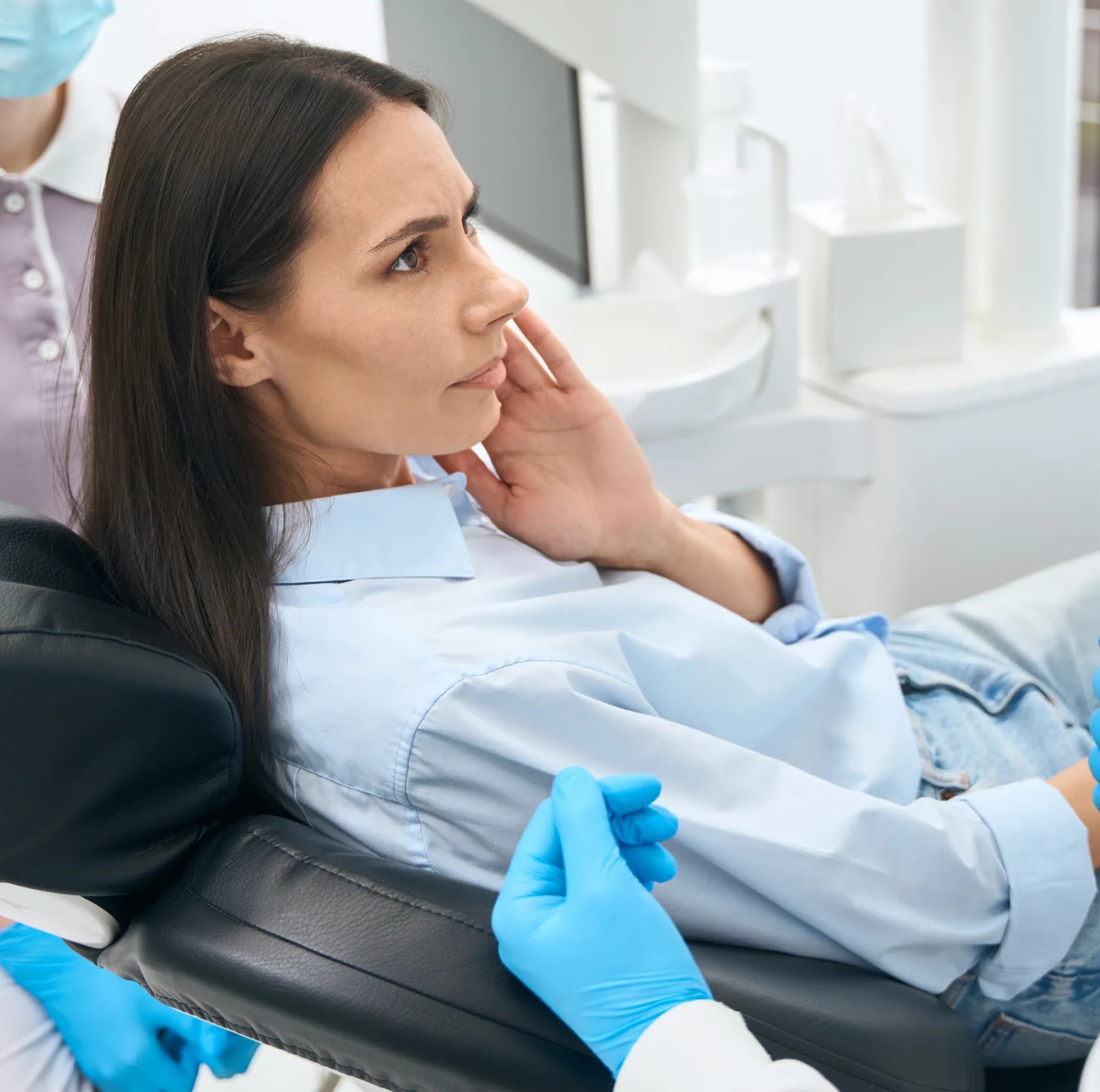 Woman sitting at the dentist chair worried