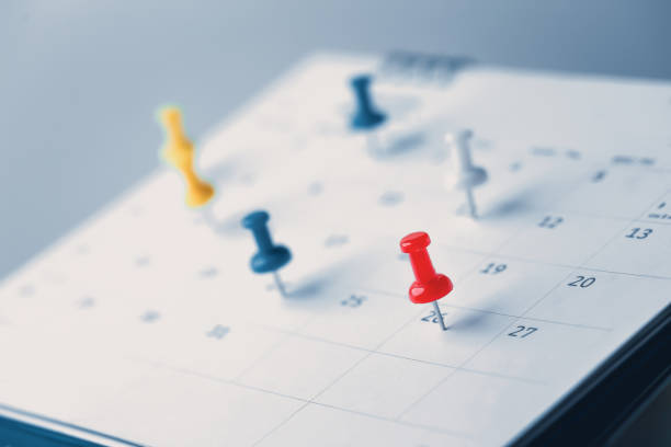 Colorful push pins marking important dates on a calendar