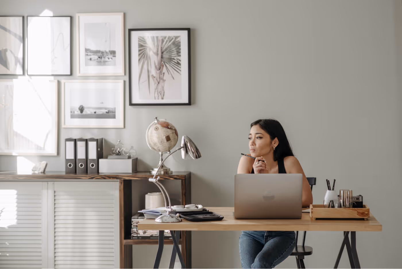 A woman sitting at a desk working on a laptop