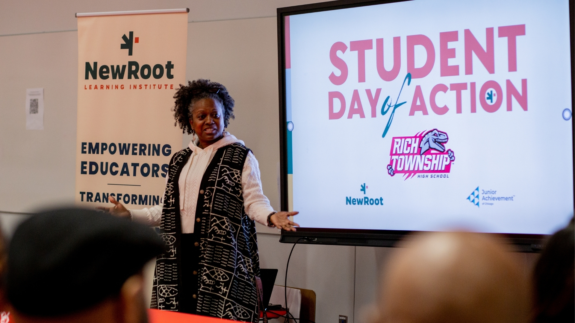 A woman standing in front of a sign that says Student Day of Action.