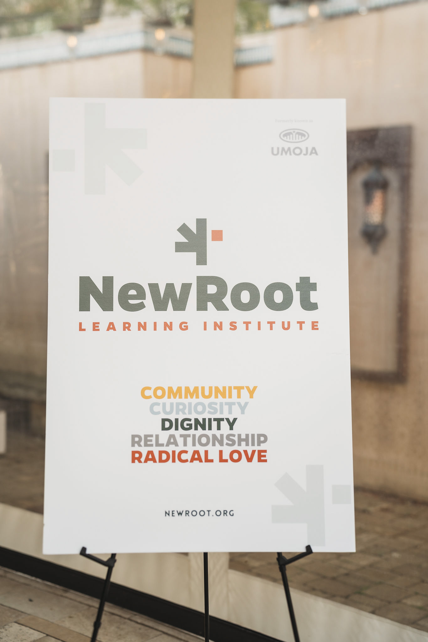 A poster-board with NewRoot Event branding on it