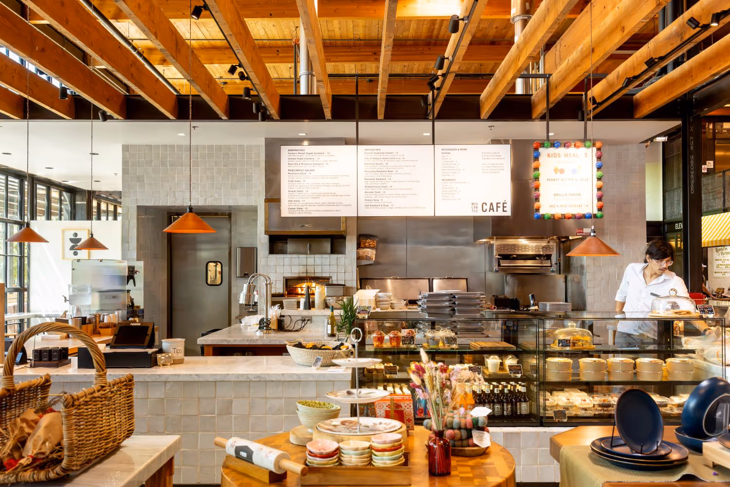 Mercantile Cafe's counter with menu in back along with merchandise for sale on a table