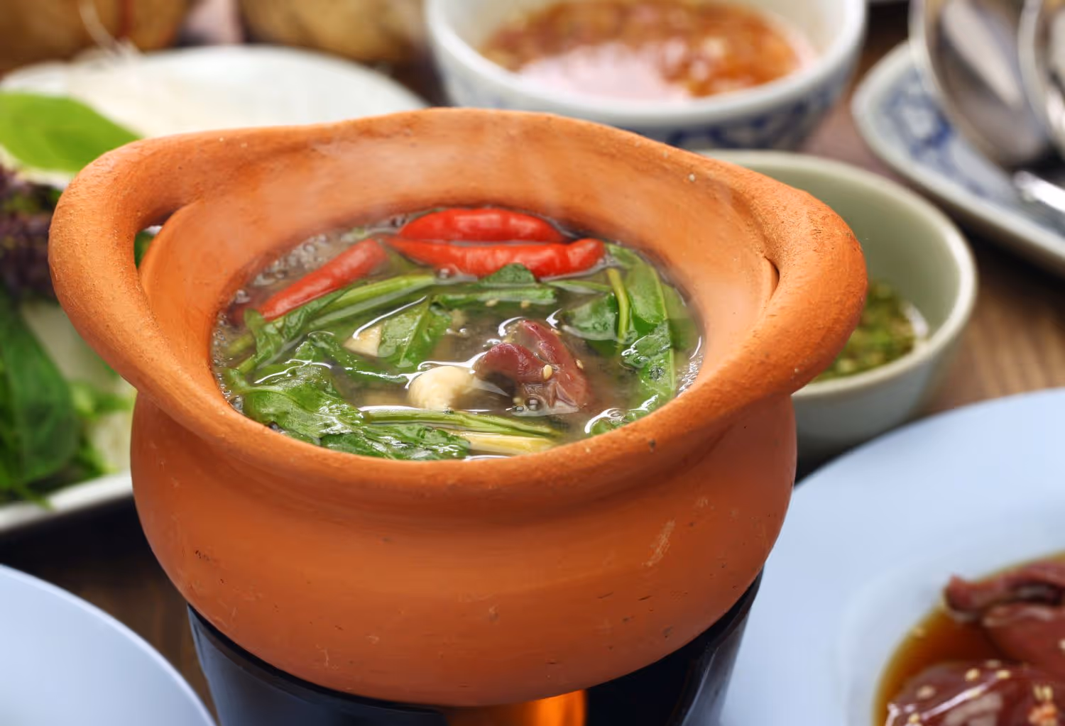 Clay pot with broth and vegetables