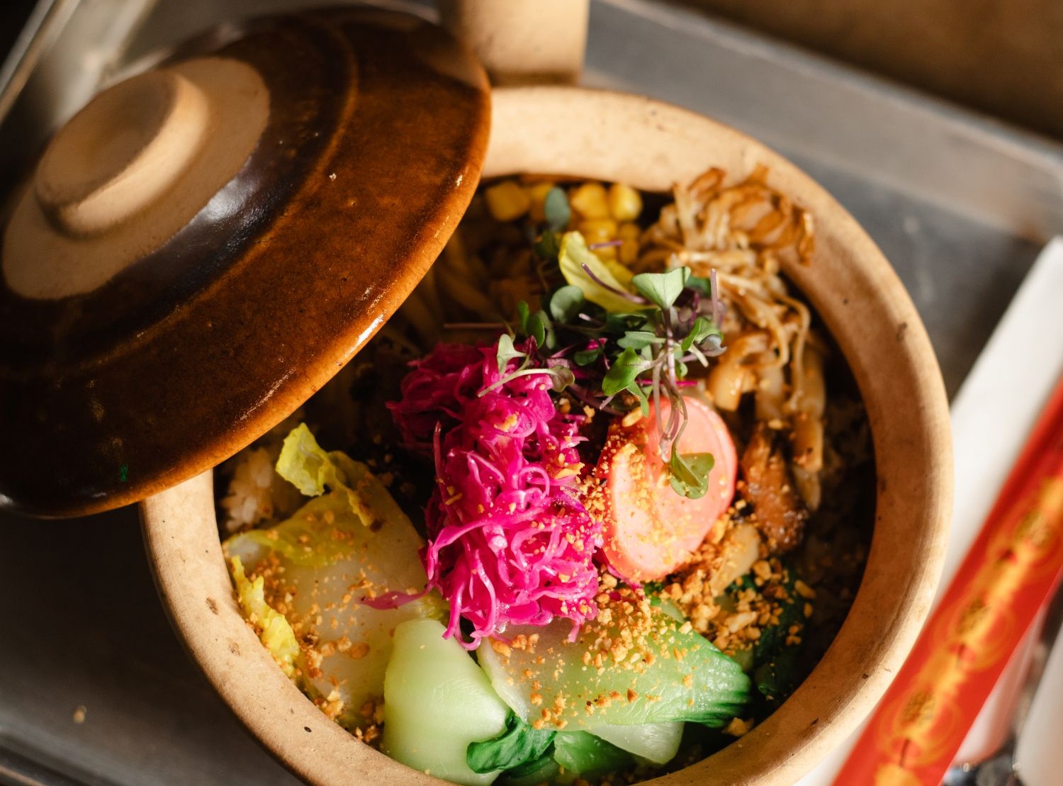 clay pot filled with various vegetables and rice