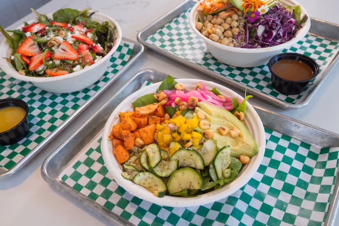 Three seasonal summer salads bowls featuring ingredients like cucumber, avocado, sweet potato, and chickpeas