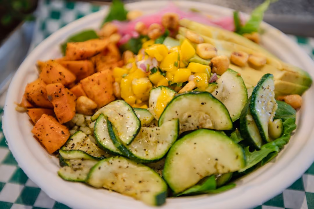 Close up of Salad Bowl with cucumber, avocado, sweet potato, and corn.