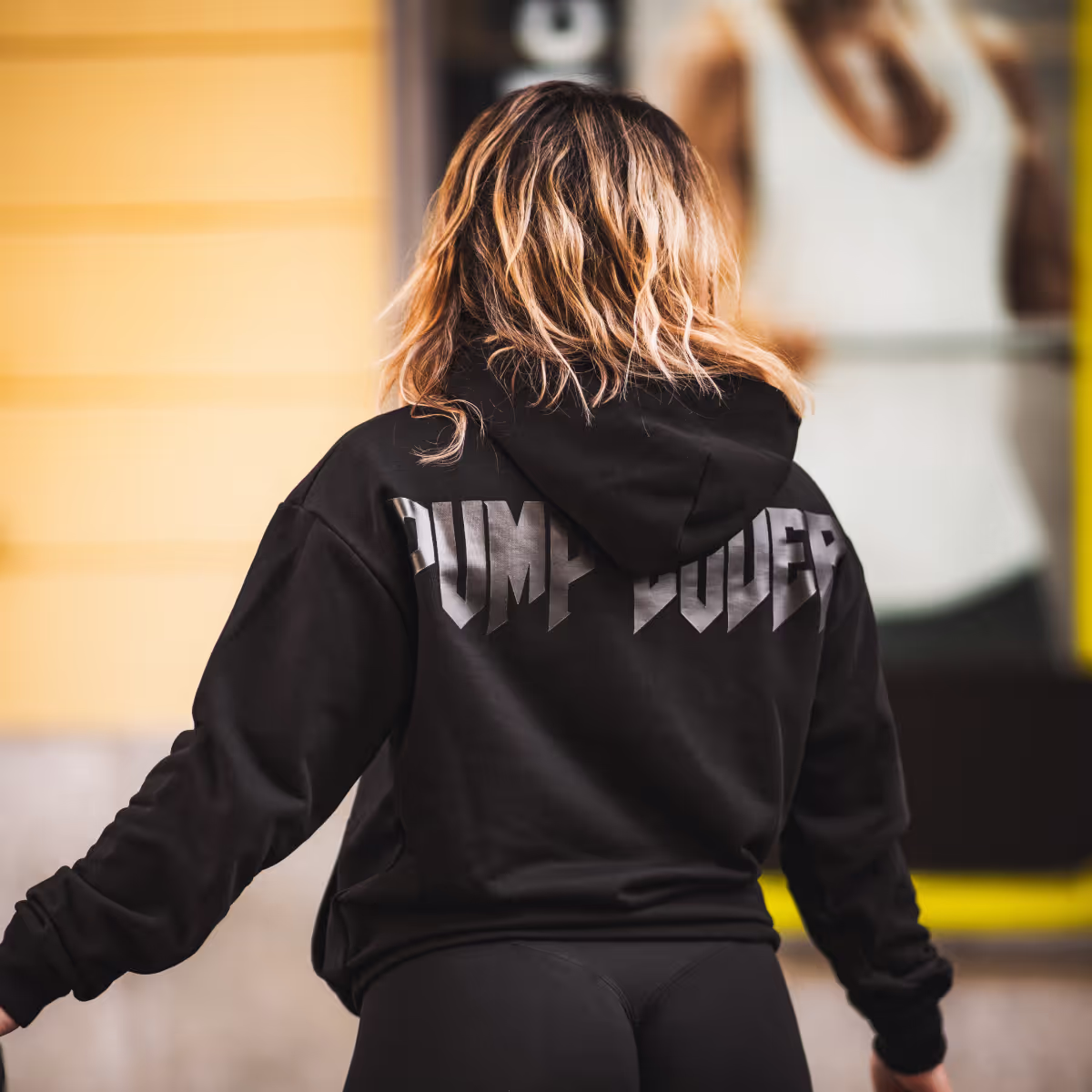 foto di una ragazza con addosso la felpa Pump Cover Builtdifferent