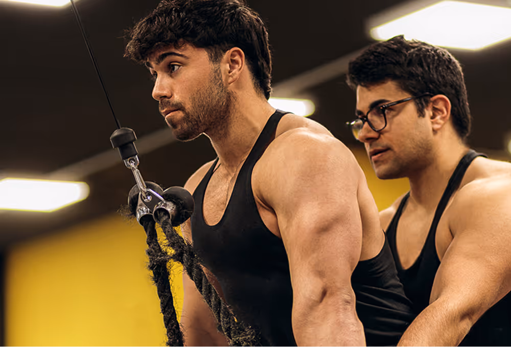 foto di Matteo, coach Builtdifferent mentre aiuta un atleta a fare un esercizio in palestra
