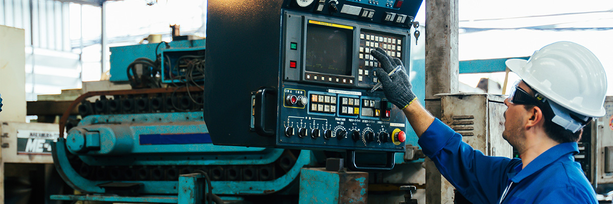 A factory worker in a harsh outdoor environment interfacing with an industrial computer
