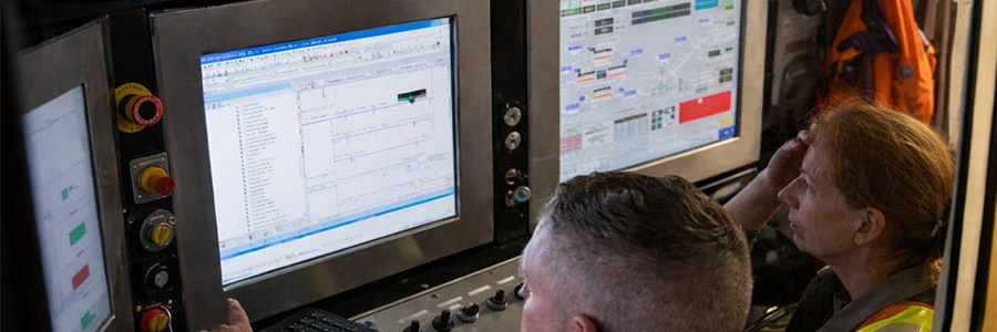 Workers in an industrial facility at their workstation using VarTech Systems' monitors