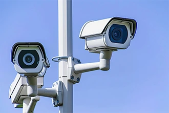Outdoor security cameras mounted on a pole, representing VarTech's weatherproof computing solutions for security systems