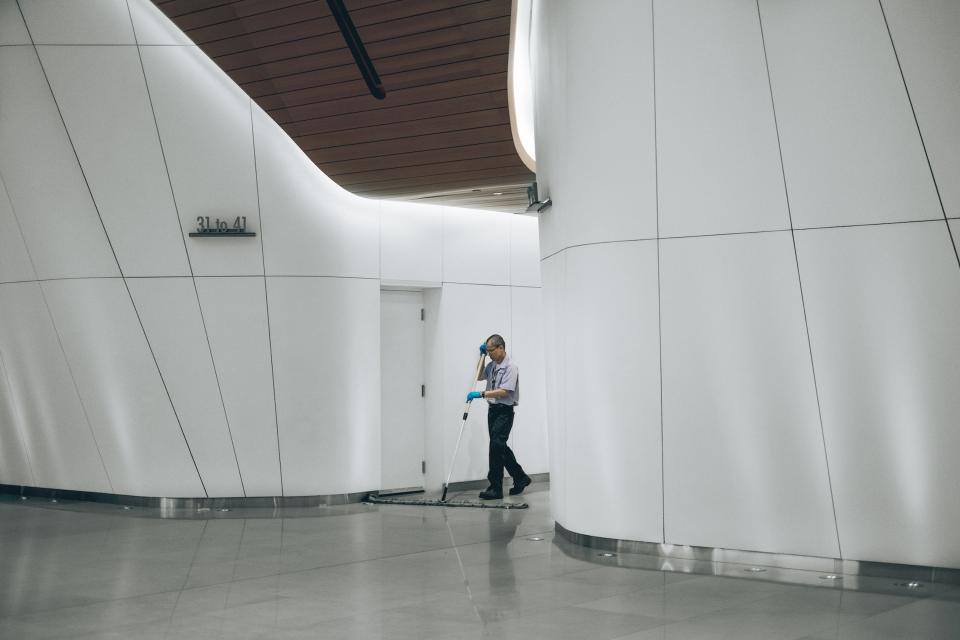 Agent d'entretien dans un couloir moderne, secteur propreté et services