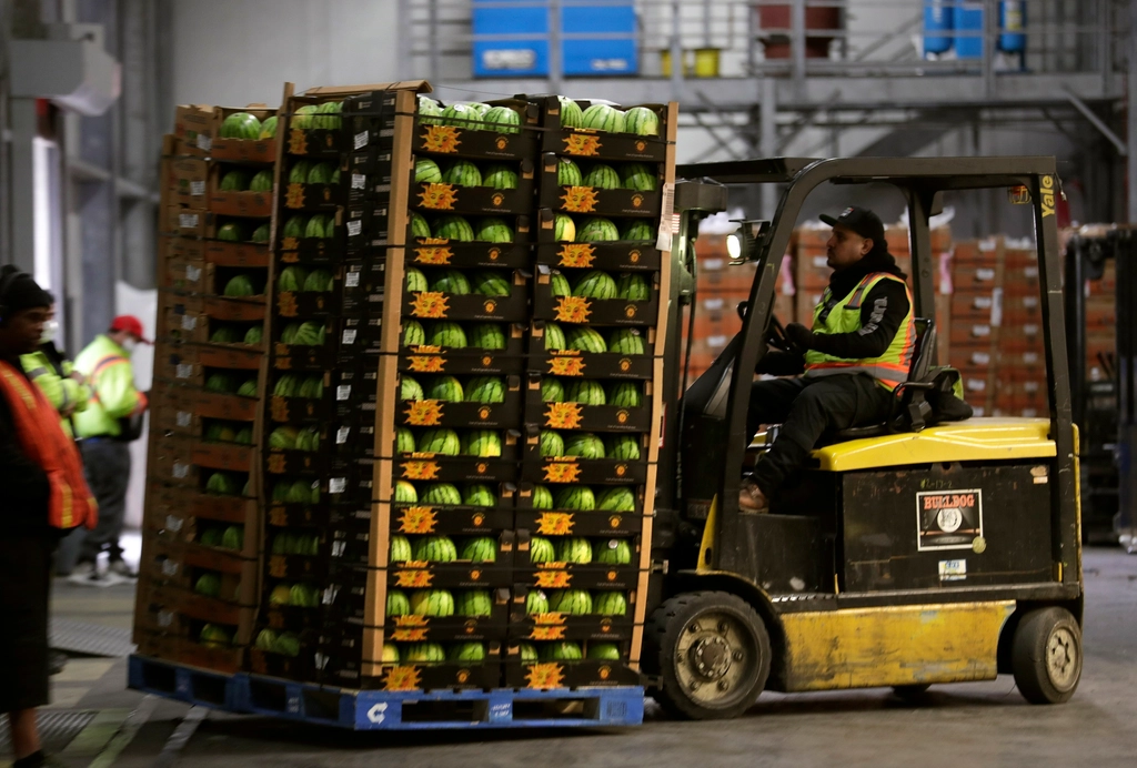 Cariste déplaçant une palette de caisses