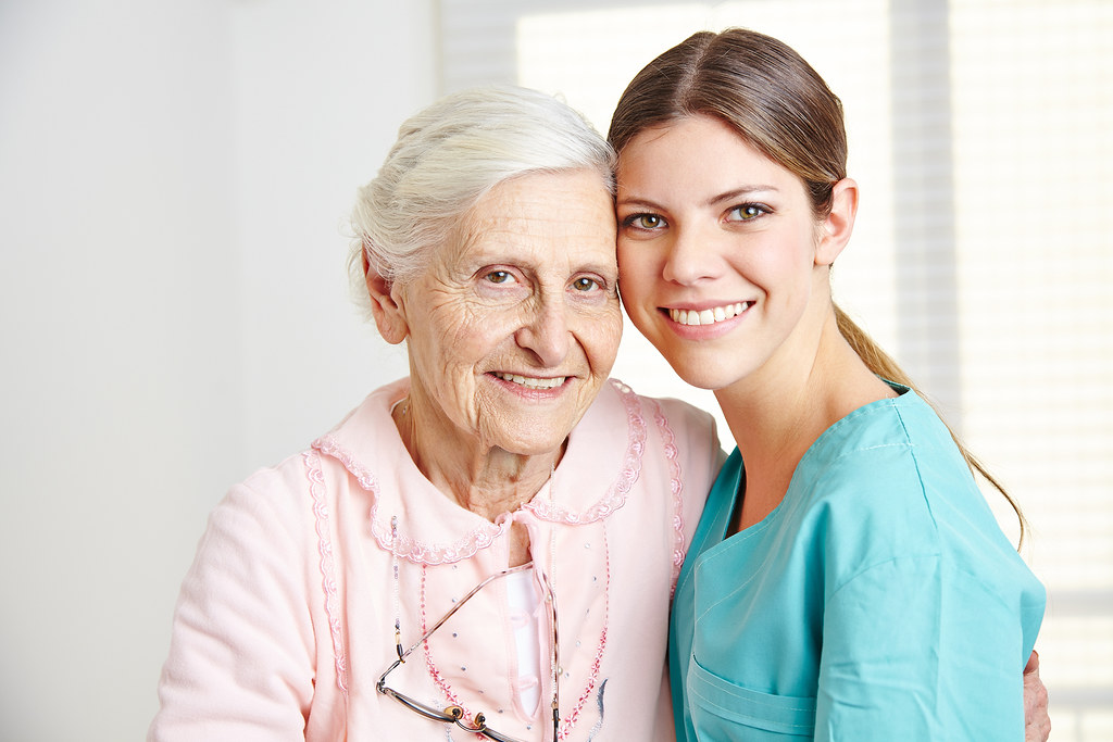 Smiling care assistant with an elderly lady