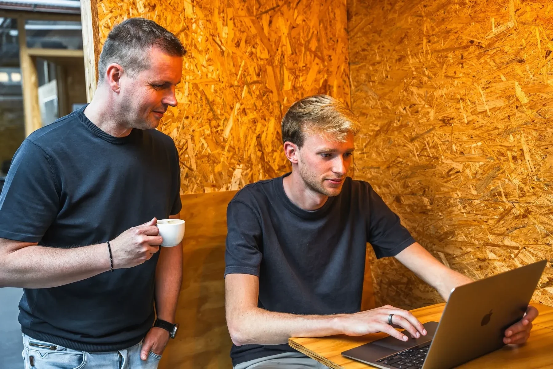 Twee collega's van DAYLEE overleggen achter een laptop