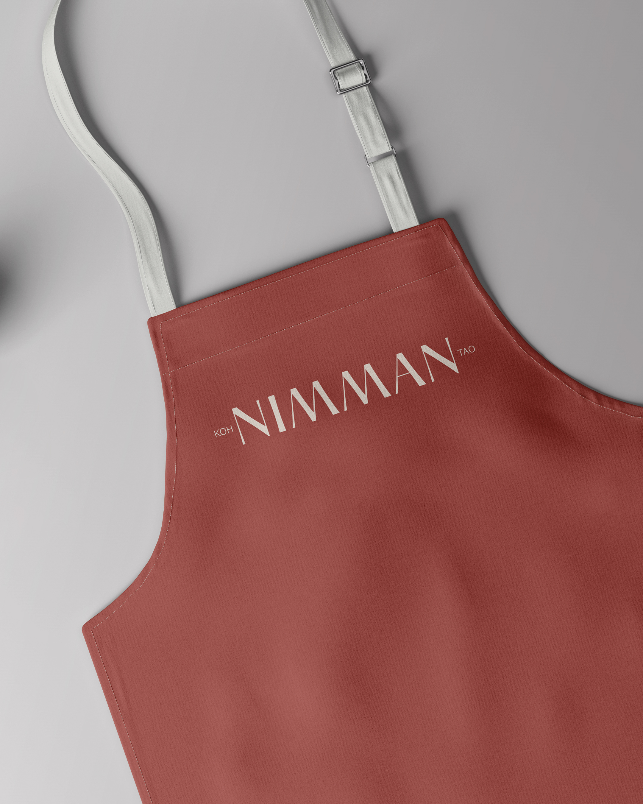 Tablier rouge avec des bretelles blanches et le texte 'KOH NIMMAN TAO' imprimé en blanc.