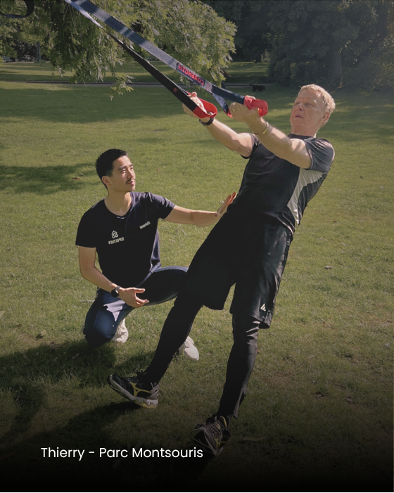 Coaching fonctionnel haut de gamme en extérieur : Félix Khau guide un client senior dans un exercice au TRX.