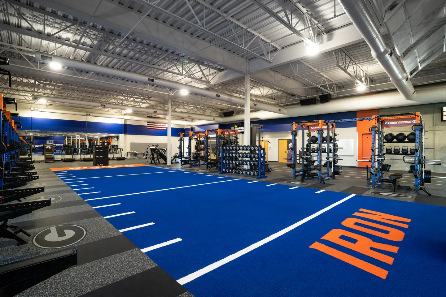 Custom ATTACK Performance Turf with sprint lane markings integrated into a PLAE strength training facility featuring custom ICONx racks.