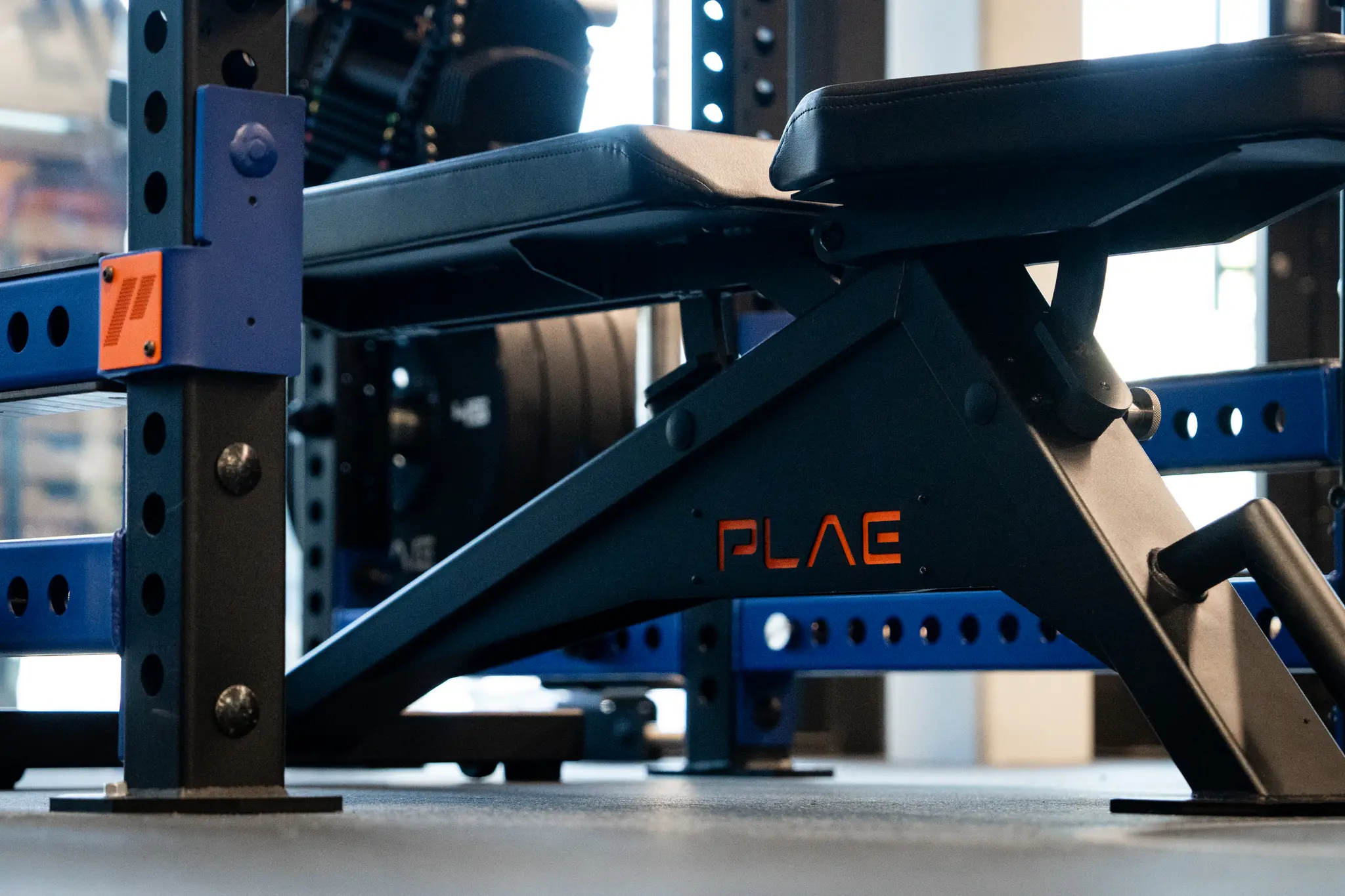 PLAE flat bench integrated within a custom branded ICONx rack training station on ACHIEVE Rubber Flooring.
