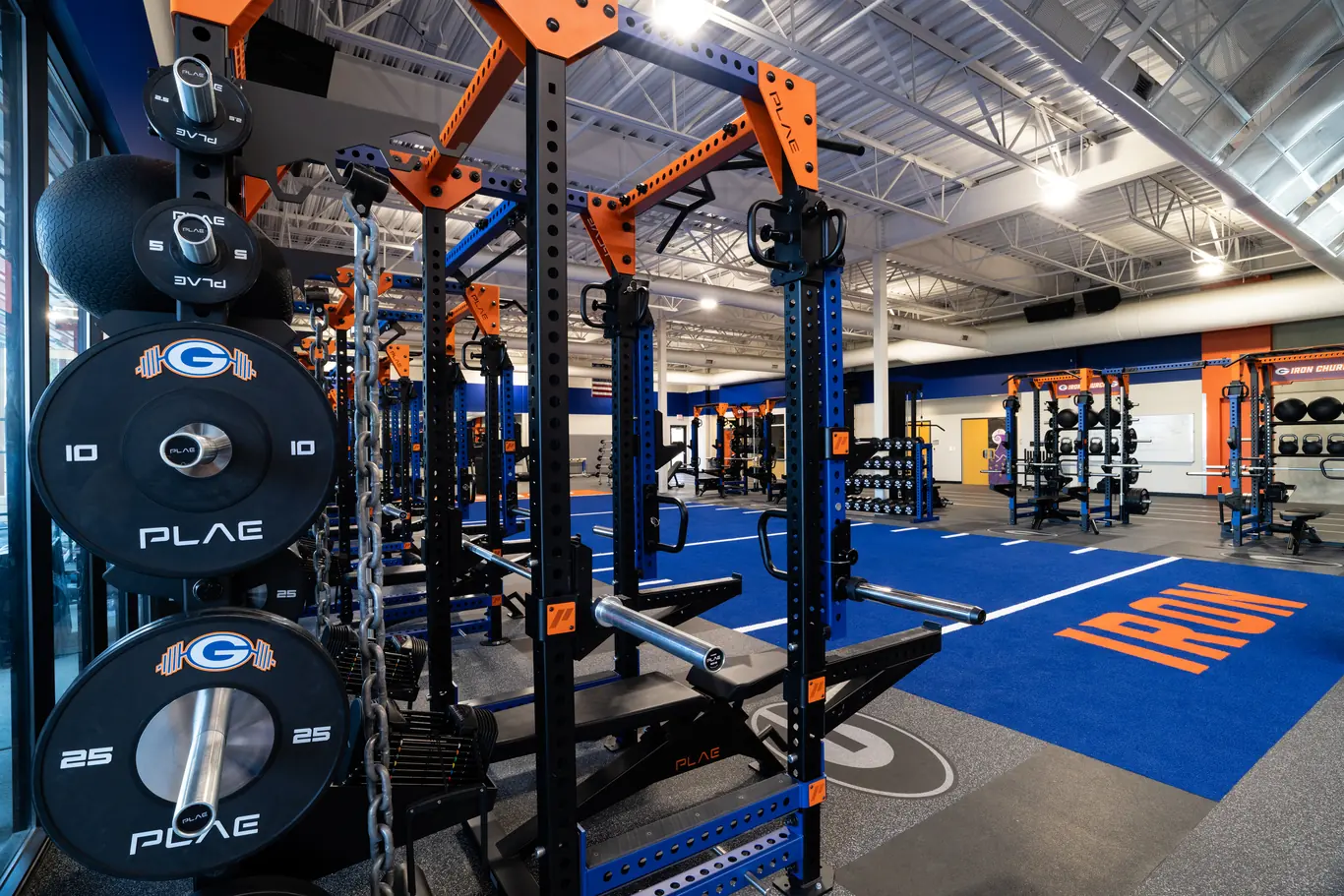 Custom branded PLAE ICONx rack with integrated weight storage positioned alongside custom ATTACK Performance Turf.