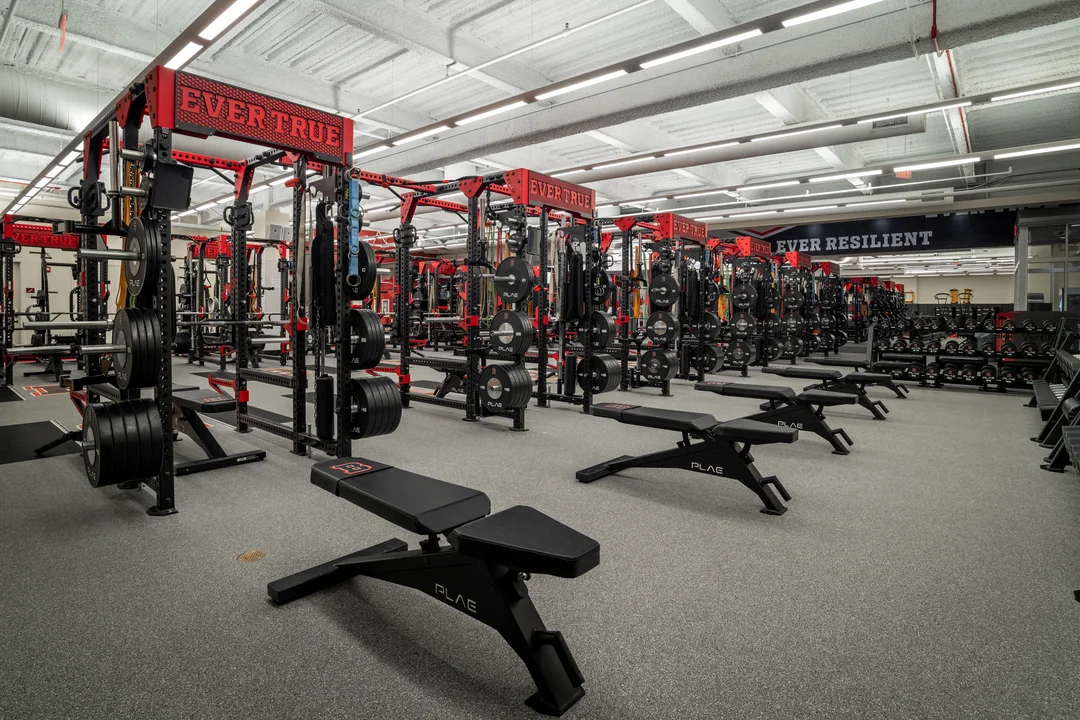 Wide-angle view of custom PLAE ICONx strength racks with PLAE benches and integrated weight storage at Brown University.