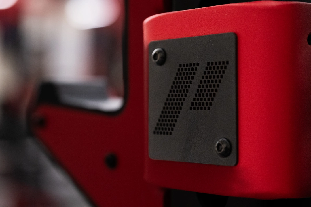 Macro detail of a custom PLAE ICONx rack attachment featuring premium steel construction and branded plate detailing.