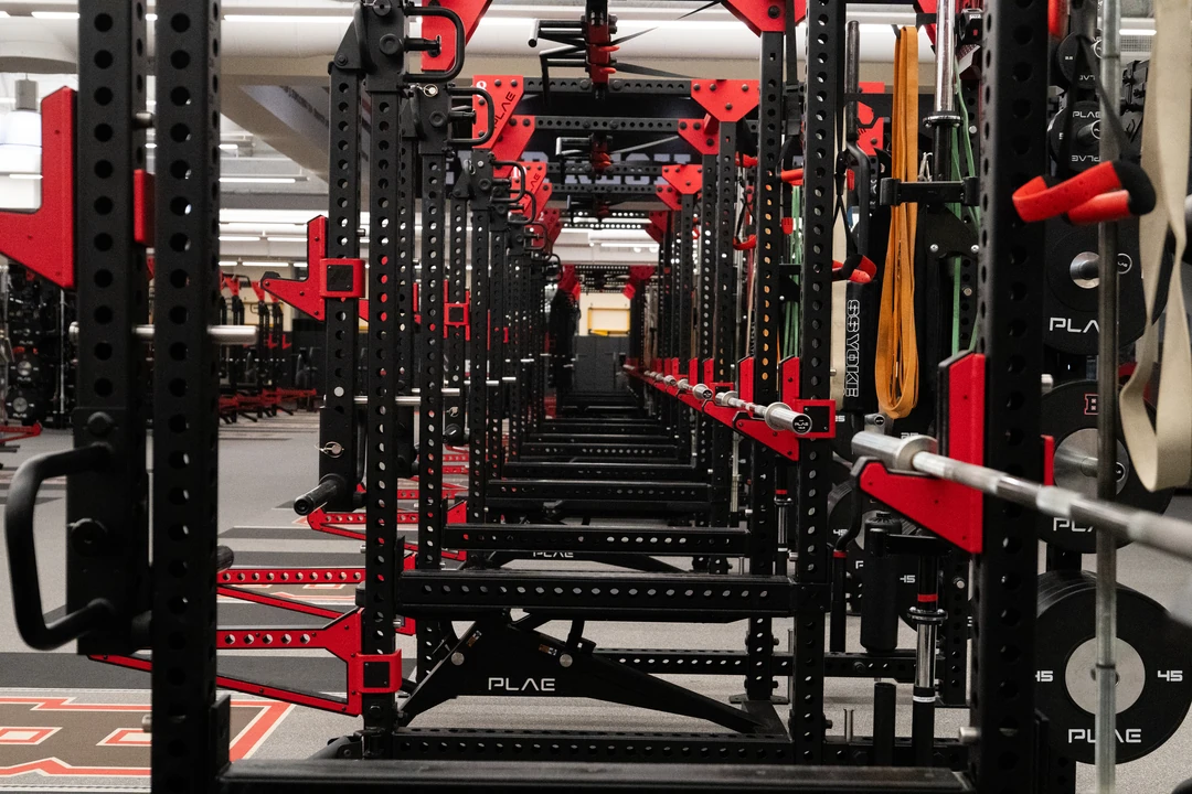 Perspective view through a row of custom PLAE ICONx strength racks highlighting integrated storage and custom lifting stations.