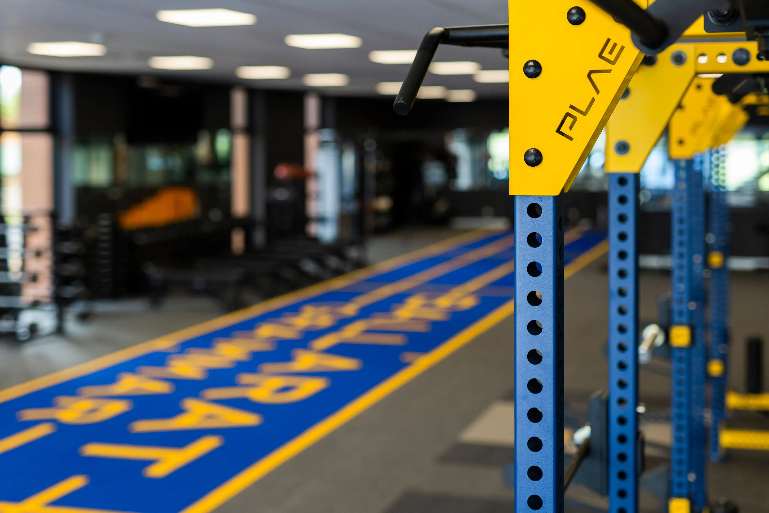 Blue PLAE ATTACK turf running track branded for Ballarat Grammar beside yellow PLAE ICON X racks