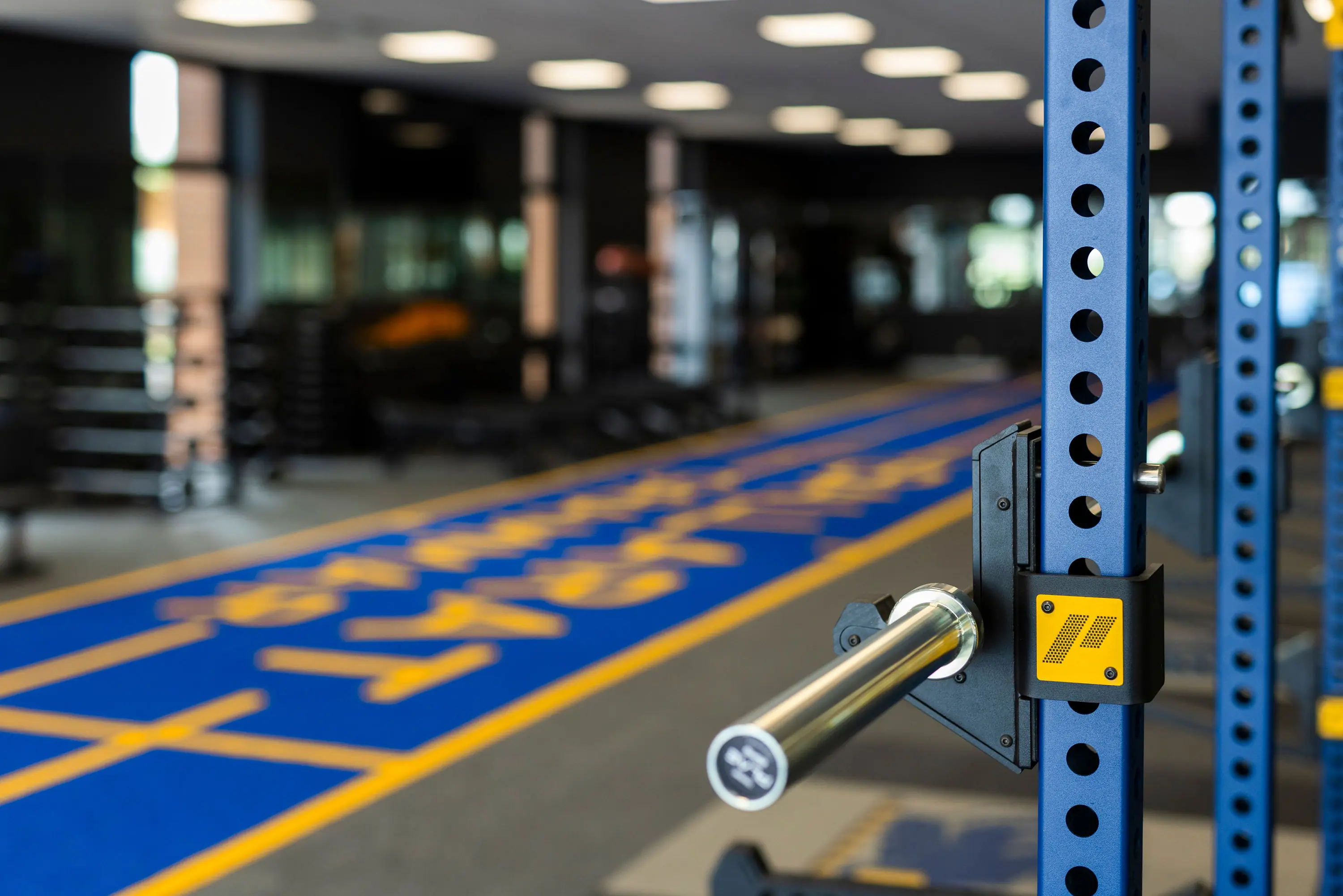 PLAE ICON X rack upright and barbell beside the blue ATTACK turf sprint lane branded for Ballarat Grammar