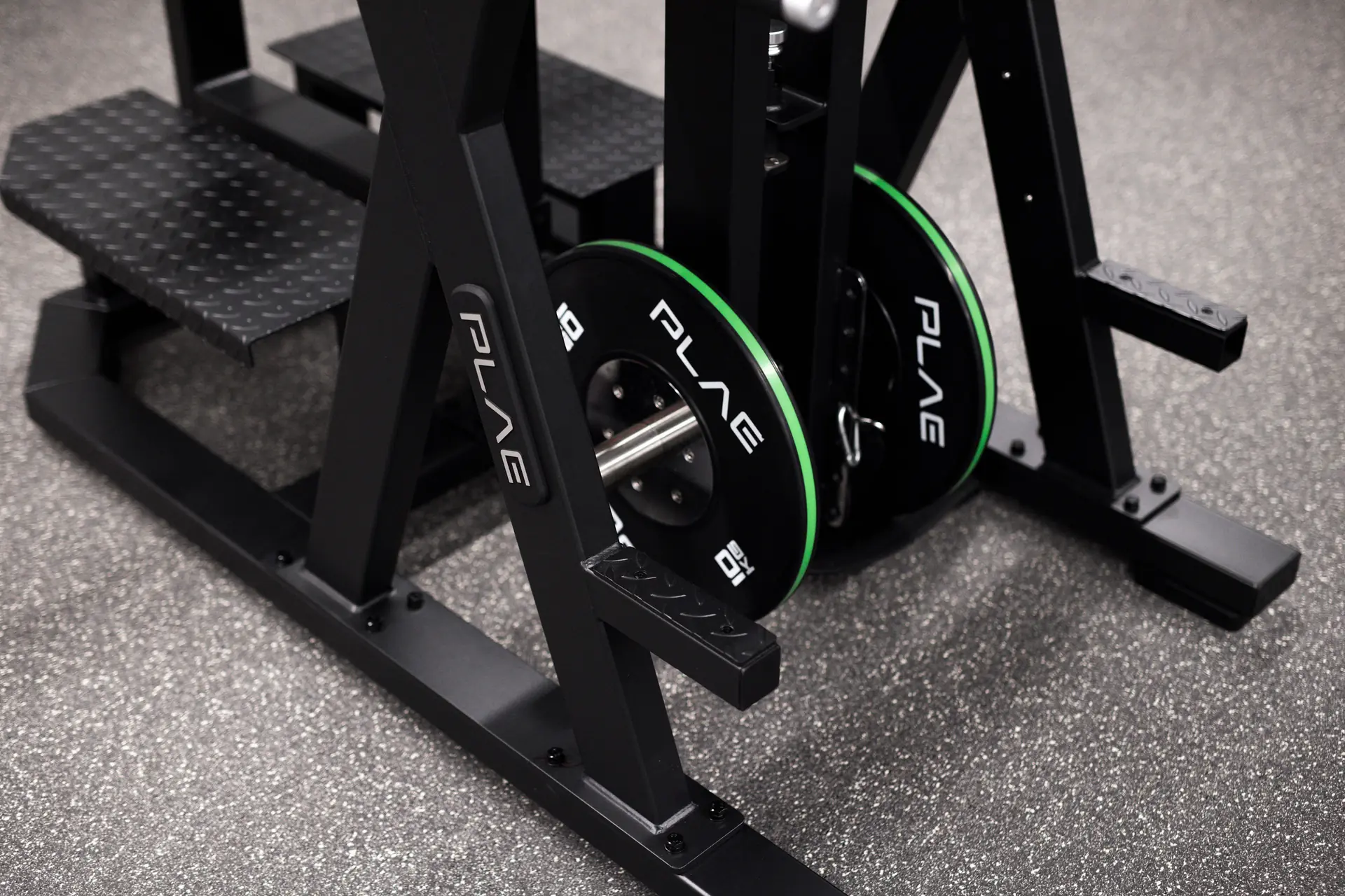 PLAE plyometric step platform with a green-rimmed PLAE bumper plate on the rubber flooring at Fitness First Richmond